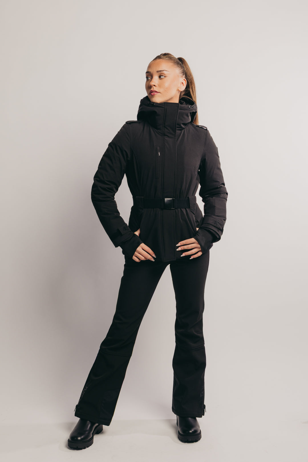 Person wearing a black winter outfit on a plain background