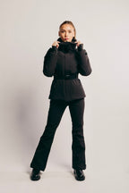 Person wearing a black winter outfit on a light gray background