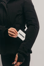 Black ski jacket with a visible brand logo on the sleeve against a neutral background